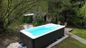 a large bath tub in a yard with trees at Na Hamaku Jacuzzi & Sauna in Marzysz