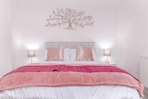 a bedroom with a large bed with pink blankets and pillows at Hope Street in Filey