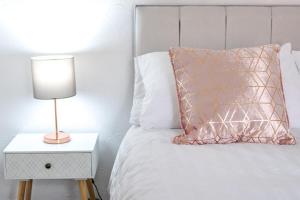 a bed with a pillow and a lamp on a night stand at Hope Street in Filey