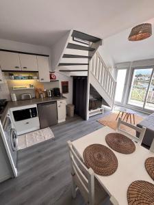 a large kitchen and living room with a staircase at Ti Mad, Echappée belle à La Baule - mer et piscine in Guérande