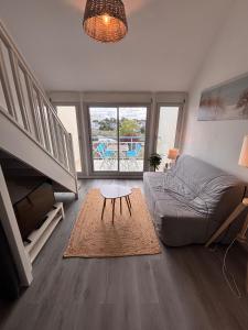 a living room with a couch and a table at Ti Mad, Echappée belle à La Baule - mer et piscine in Guérande +21 photos