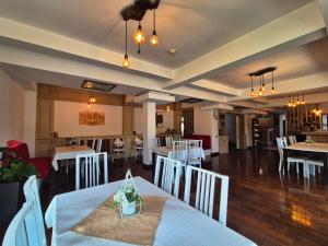 a restaurant with white tables and white chairs at Soare-n Maramureș in Budeşti