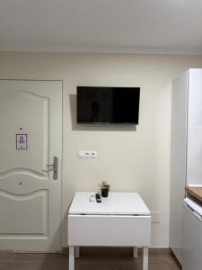 a white room with a white refrigerator and a tv on the wall at PENSIÓN ISBEL in Málaga