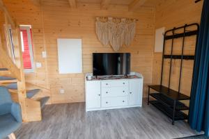 a living room with a tv and a cabinet with a television at Domki w Jarzębinach - Domek z widokiem in Piechowice