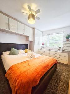 a bedroom with a large bed with an orange blanket at Central Hideout in Birmingham