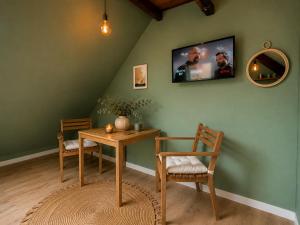 a room with a table and two chairs and a tv at Cabane urbaine in Sarreguemines