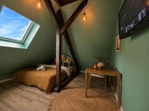 a bedroom with a bed and a table and a window at Cabane urbaine in Sarreguemines