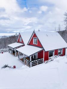 a red house with snow on the roof at Domki w Jarzębinach - Domek z widokiem in Piechowice +31 photos