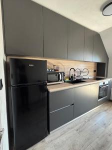 a kitchen with a black refrigerator and a microwave at Aneva home in Ruse