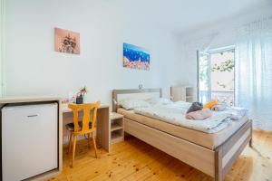a bedroom with a bed and a desk and a chair at Bed & Breakfast Haus Lucija in Baška