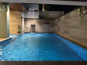 a large swimming pool with blue water in a room at Abirami Residency in Pondicherry