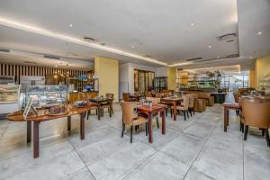 a restaurant with wooden tables and chairs in a room at Sandton Skye Unit 1110 in Johannesburg