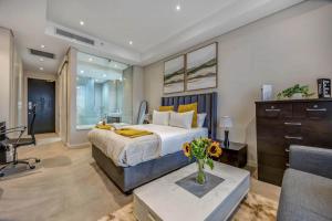 a bedroom with a bed with a vase of flowers on a table at Sandton Skye Unit 1110 in Johannesburg +8 photos