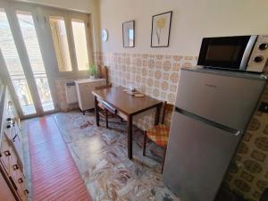a kitchen with a refrigerator and a table with a microwave at Casa di Marie in Mafalda
