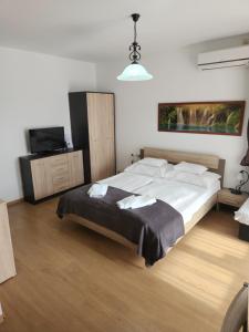 a bedroom with a large bed and a tv at Fortuna 7 in Hévíz