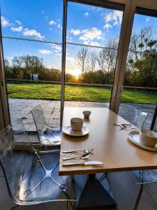 a table and chairs with a table and a window at Brit Hotel Vannes - Theix Golfe du Morbihan in Theix