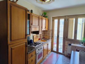 a kitchen with wooden cabinets and a stove top oven at Casa di Marie in Mafalda