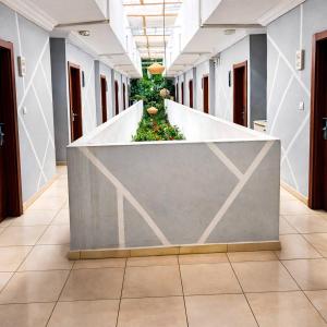 a corridor of an office building with a wall with plants at Hotel Nana in Abidjan
