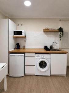 a kitchen with a washing machine and a sink at PENSIÓN ISBEL in Málaga