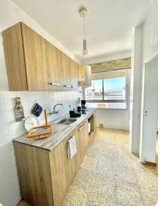 a kitchen with wooden cabinets and a sink and a window at Barbate Beach Apartment in Barbate