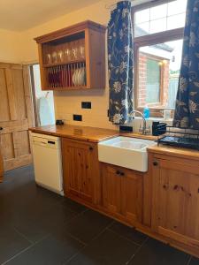 a kitchen with wooden cabinets and a sink and a window at Ivanhoe Home from Home in Freshwater +17 photos