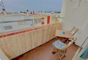 a balcony with a chair and a table on a building at Barbate Beach Apartment in Barbate