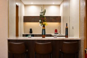 a kitchen with a bar with brown stools at Redwaves Hotel in Jeddah