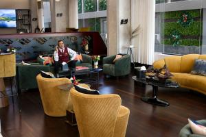 a living room with couches and chairs and a man at Redwaves Hotel in Jeddah