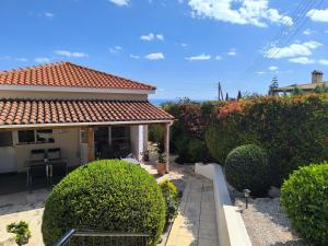 a house with a garden with bushes and trees at Villa Best Holiday Sea View Private Pool near Coral Bay with Garden and BBQ in Peyia