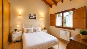 a bedroom with a white bed and a window at La Casa de Pría in Garaña