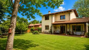 a house with a green yard with a tree at La Casa de Pría in Garaña