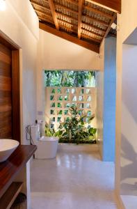 a bathroom with a white tub and a plant at Confluence Siargao in General Luna