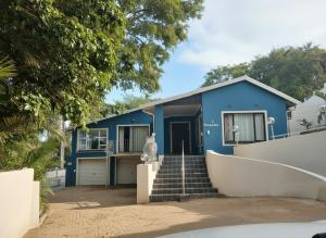 a blue house with stairs in front of it at Nolangeni Lodge in Margate