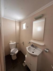 a small bathroom with a toilet and a sink at Sea View Studios, Harbour Beach, Bali in Bali