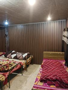 a room with two beds in it with a wall at Himalayan siddhi yog aashram in Badrinath