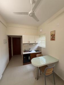 a kitchen with a table and chairs in a room at Little Retreats in Nedumbassery