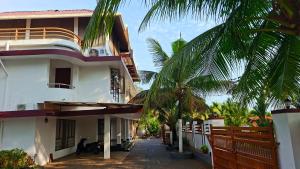 a building with a palm tree in front of it at Captains Cabin, Alleppey- A Premium Backwater Mansion in Alleppey