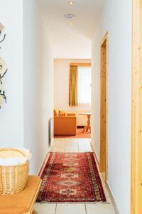 a hallway with a living room with a couch and a rug at Appartments Bergland an der Brunnachbahn in Bad Kleinkirchheim +121 photos