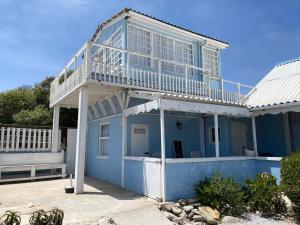 a blue house with a balcony on top of it at Port Nolloth Beach Shack in Port Nolloth