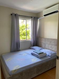a bed in a bedroom with a window at Cebu's Affordable Condo Rentals in Cebu City