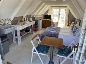 a bedroom with a bed and a desk and a sink at Port Nolloth Beach Shack in Port Nolloth