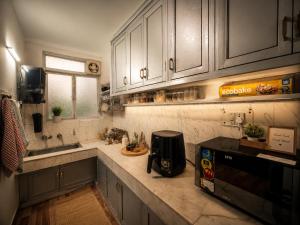 a kitchen with white cabinets and a counter top at Checkpoint backpacker in New Delhi