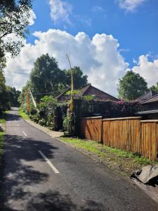 an empty road with a fence and a house at The Sinta Bali in Munduk