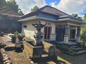 a small house with a fountain in front of it at The Sinta Bali in Munduk