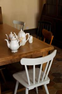 a wooden table with a white tea set on it at La Selva in Busserolles +27 photos