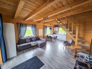 a living room with a couch and a staircase at Domki w Jarzębinach - Domek z widokiem in Piechowice