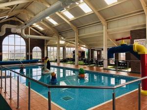 a large indoor pool with a water slide at Unique 2 bed lodge lyons Robinhood in Rhyl