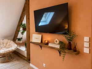 a living room with a television on a wall at Voyage à Bali in Sarreguemines