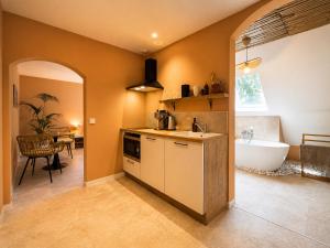 a kitchen with a tub and a sink and a bath room at Voyage à Bali in Sarreguemines