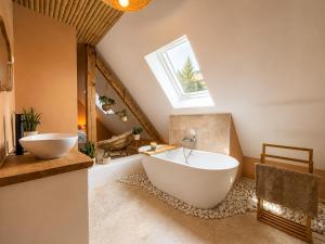 a bathroom with a large white tub and a skylight at Voyage à Bali in Sarreguemines